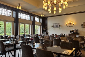 Breakfast room of Amrâth Hotel DuCasque with a view of the Vrijthof in Maastricht, furnished with set tables, classic chairs, and large windows that let in plenty of daylight.