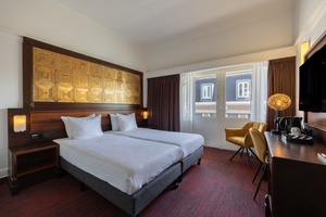 Comfortabele hotelkamer in Amrâth Hotel DuCasque met tweepersoonsbed, kunstzinnig hoofdbord en aangrenzende badkamer met inloopdouche.