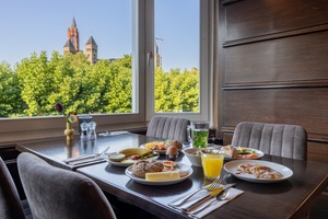 Set table with a flower vase in the restaurant of Amrâth Hotel DuCasque, overlooking the Vrijthof in Maastricht.