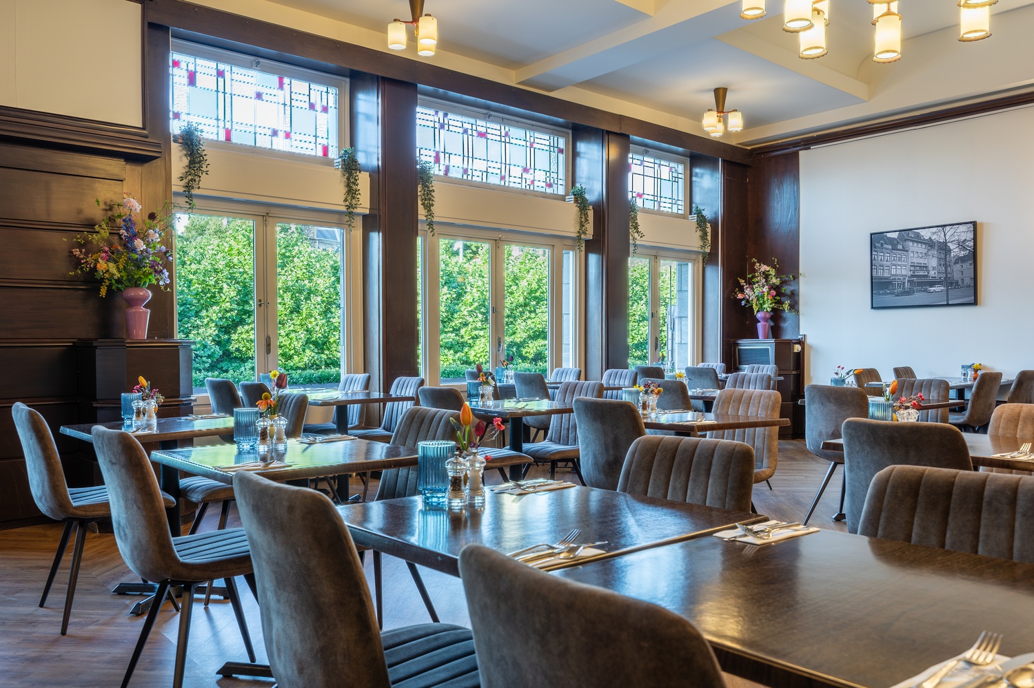 Ontbijtzaal van Amrâth Hotel DuCasque met grote ramen en uitzicht op het Vrijthof en historische panden.